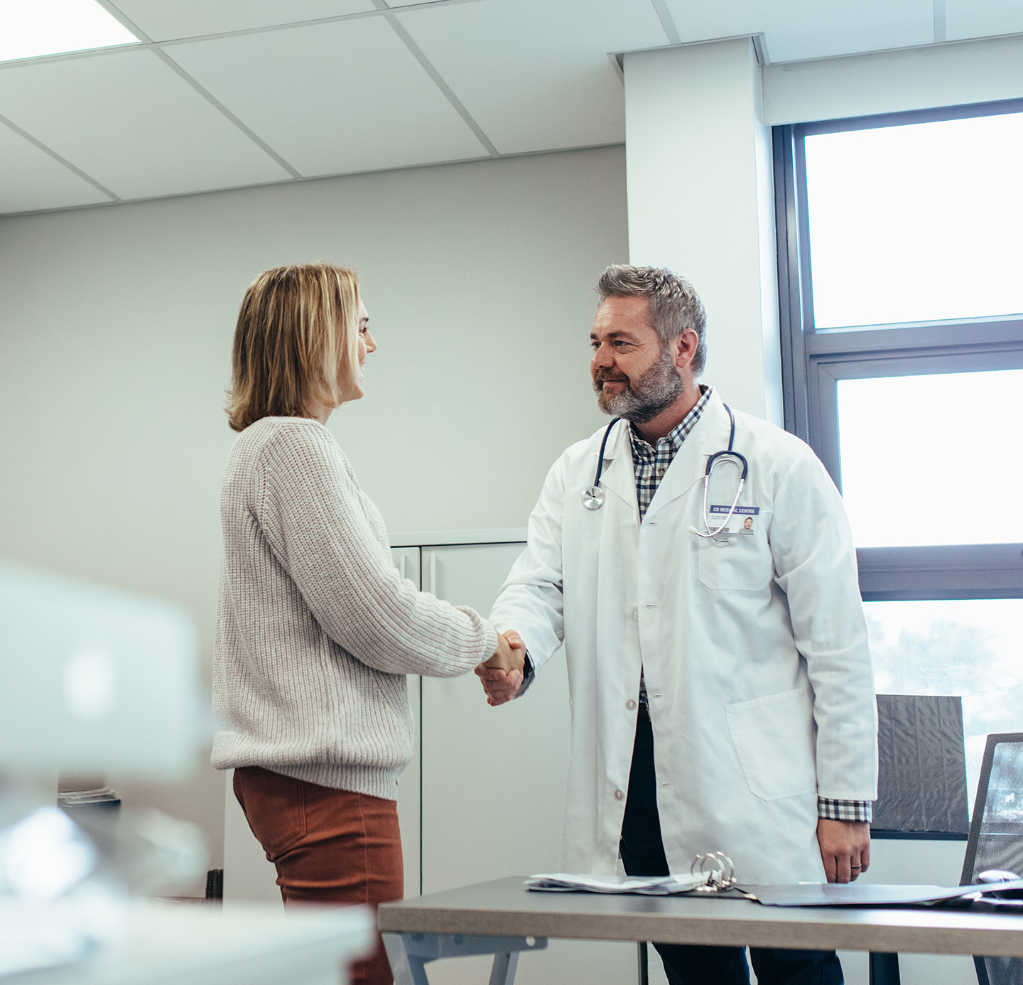 Doctor shaking hands with happy patient